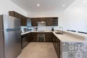 a kitchen with wooden cabinets and a stainless steel refrigerator at Laguna Shores Resort in Puerto Peñasco