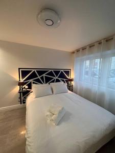 1 dormitorio con 1 cama blanca grande con almohadas blancas en studio 3 au cœur de Périgueux, en Périgueux