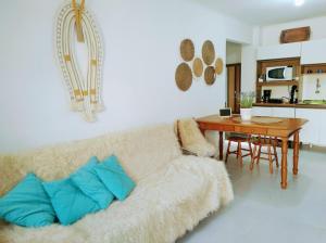 uma sala de estar com um sofá e uma mesa em Morada Héstia em Imbé