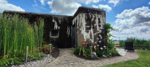 un antico edificio in pietra con fiori in un giardino di Au Bunker 67 a Rott