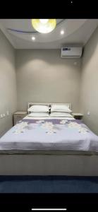a bedroom with a large bed with a blue blanket at LOONA FAMILY HOSTEL in Tashkent