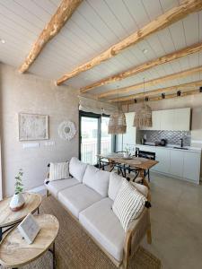a living room with a white couch and a table at Ático Superior con Terraza Vistas Jacuzzi y Wifi - Poniente Penthouse in Tarifa