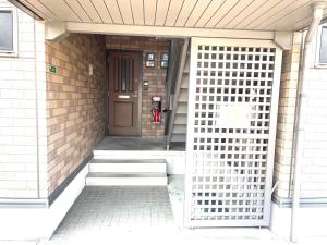 una puerta delantera de una casa con una boca de incendios delante en Sapan Hasegawa - Vacation STAY 14809 en Kitakyushu