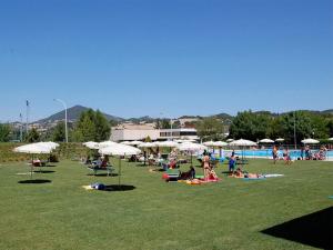 a group of people laying on the grass near a pool at Il piccolo casale 1950 in Fabriano