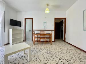 - un salon avec une table et une salle à manger dans l'établissement Apartamentos Ancora Romana, à Calafell
