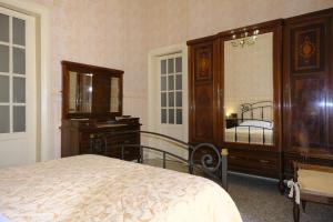 1 dormitorio con cama, tocador y espejo en Palazzo Vitrano - tourist apartment en Catania