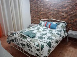 una cama en una habitación con una pared de ladrillo en Piso delante de la playa La Pineda con 2 habitaciones, en La Pineda