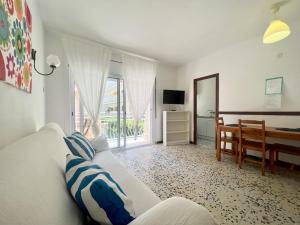 - un salon avec un canapé blanc et une table dans l'établissement Apartamentos Ancora Romana, à Calafell