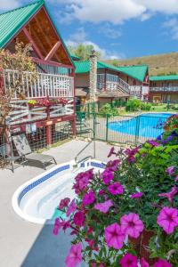 a house with a swimming pool and pink flowers at AbbyCreek Inn in Winthrop