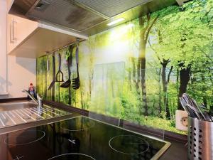 eine Küche mit einem Wandbild von Bäumen in der Unterkunft Cosy and lovingly furnished apartment in the Black Forest in Villingen-Schwenningen