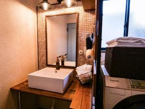 La salle de bains est pourvue d'un lavabo blanc et d'un miroir. dans l'établissement Villa228KASAMA - Vacation STAY 92175v, à Kasama