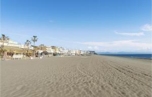 una playa de arena con edificios, palmeras y el océano en Gorgeous Apartment In Torremolinos With Kitchen, en Torremolinos