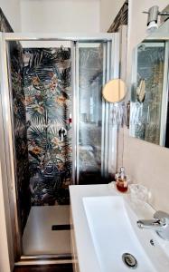 a bathroom with a shower and a white sink at Mi Garba B&B in Viareggio