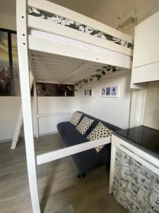 a loft bed with a couch in a room at Domus Vacanza in Milan