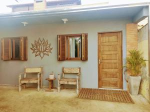 Pokój z dwoma krzesłami i drzwiami w obiekcie Morada Héstia w mieście Imbé