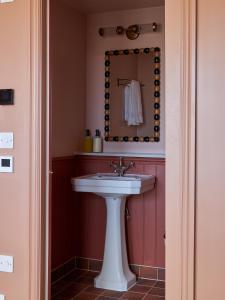 W łazience znajduje się biała umywalka i lustro. w obiekcie Margate House w mieście Kent