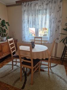 jadalnia ze stołem i krzesłami oraz oknem w obiekcie Guesthouse Irac w mieście Tuzla