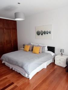 1 dormitorio con 1 cama grande con almohadas amarillas en The Artist House, en Arco da Calheta