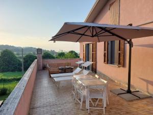 a patio with an umbrella and a table and chairs at Appartamenti Pura Vida in Fano