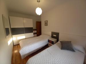 a bedroom with two beds and a light at EnFOZ PLAYA DE LLAS in Foz