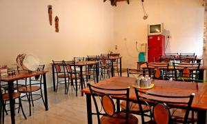 奇克马格尔Jungle Greens Homestay - Water Activities, Near to Jungle Safari的一间设有许多桌椅和红色冰箱的房间 更多37张照片