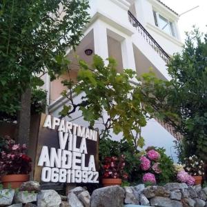 a sign in front of a building with flowers at Apartments Villa Andjela in Budva