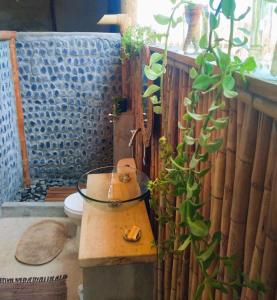 ein Badezimmer mit einem WC und einer Topfpflanze in der Unterkunft AguaMar Vichayito in Los Órganos
