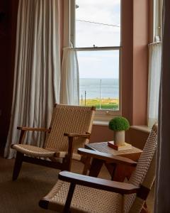Zimmer mit 2 Stühlen, einem Tisch und einem Fenster in der Unterkunft Margate House in Kent