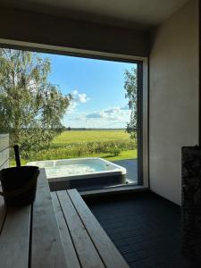 Tyrnävä的住宿－PeltoVilla，透过大窗户可欣赏到浴缸的景色