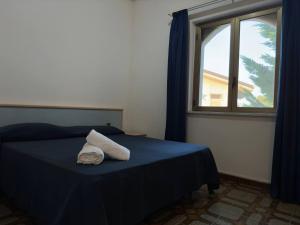 a bedroom with a blue bed with a window at Imbarcadero in Focà