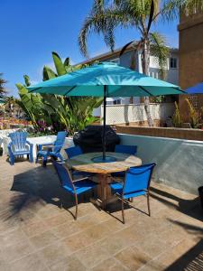 una mesa y sillas con una sombrilla en el patio en Luna Azul, cozy condo only steps to Mission Beach! Free Internet, en San Diego