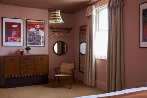 a bedroom with a bed and a dresser and a window at Margate House in Kent