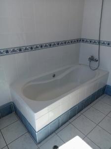 a white bath tub in a bathroom with a tile floor at The Artist House in Arco da Calheta