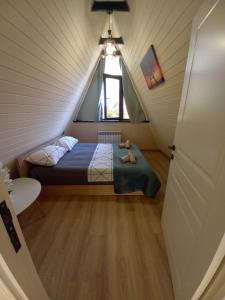 a small attic bedroom with a bed and a window at Villa NR in Gabala in Gabala
