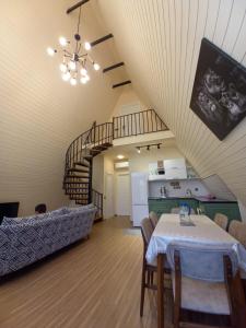 ein Wohnzimmer mit einem Tisch und einer Treppe in der Unterkunft Villa NR in Gabala in Qəbələ