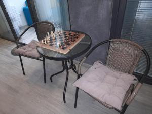 Un tablero de ajedrez sobre una mesa con dos sillas. en Natalie appartement 41, en Tiflis