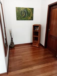 un pasillo con suelo de madera y una pintura en la pared en The Artist House, en Arco da Calheta