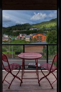 a table and two chairs on a balcony with a view at Hydeout Bakuriani in Bakuriani