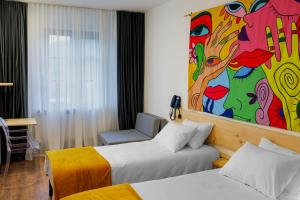 a hotel room with two beds and a painting on the wall at Hydeout Bakuriani in Bakuriani