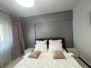ein Schlafzimmer mit einem Bett mit zwei Kissen darauf in der Unterkunft Dem ‘LuxuryApartmens in Râmnicu Vâlcea