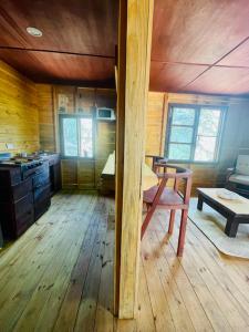 een kamer met een houten vloer en een tafel in een hut bij Los Agaves 