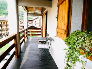 un balcón de una casa con mesa y sillas en Nuovo Appartamento moderno a Cogne, en Cogne