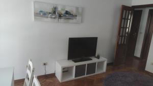 TV de pantalla plana en la parte superior de un armario blanco en Apartamento Julia en Vilagarcía de Arousa