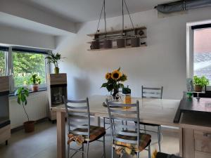 eine Küche mit einem Holztisch mit Stühlen und einem Esszimmer in der Unterkunft Ferienhaus La Farfalla in Munster im Heidekreis