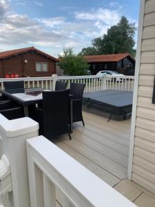 a patio with a table and chairs on a deck at Hot tub breakaways with castle view in Lincolnshire