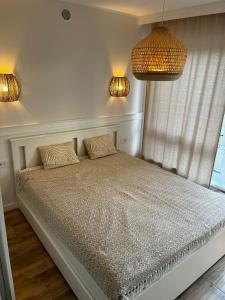 um quarto com uma cama com duas almofadas e duas luzes em Apartament Szumilas Rowy em Rowy