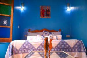 Dar Noursinn Fez في فاس: غرفة نوم زرقاء مع سرير بجدار ازرق
