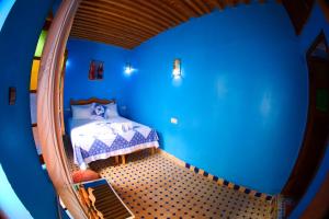 um quarto com uma cama num quarto azul em Dar Noursinn Fez em Fez