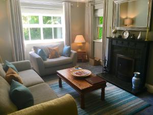 a living room with a couch and a fireplace at Chatton Park House Adult Only in Chatton