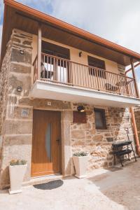 Casa de piedra con balcón y puerta de madera en Casa da Vovó Luisa, 